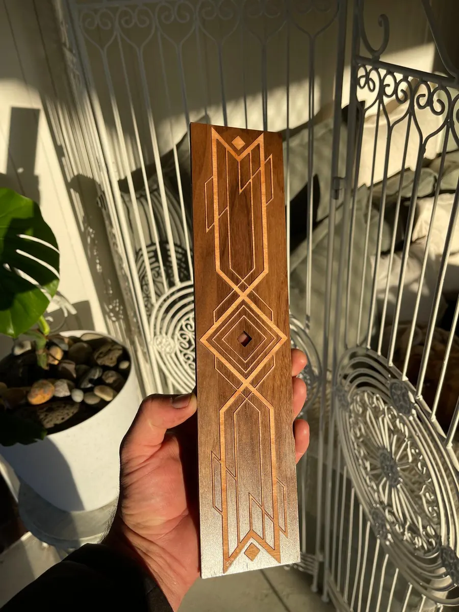 Art deco geometric laser cut timber inlay panel in dark stained wood with pale inlaid linework