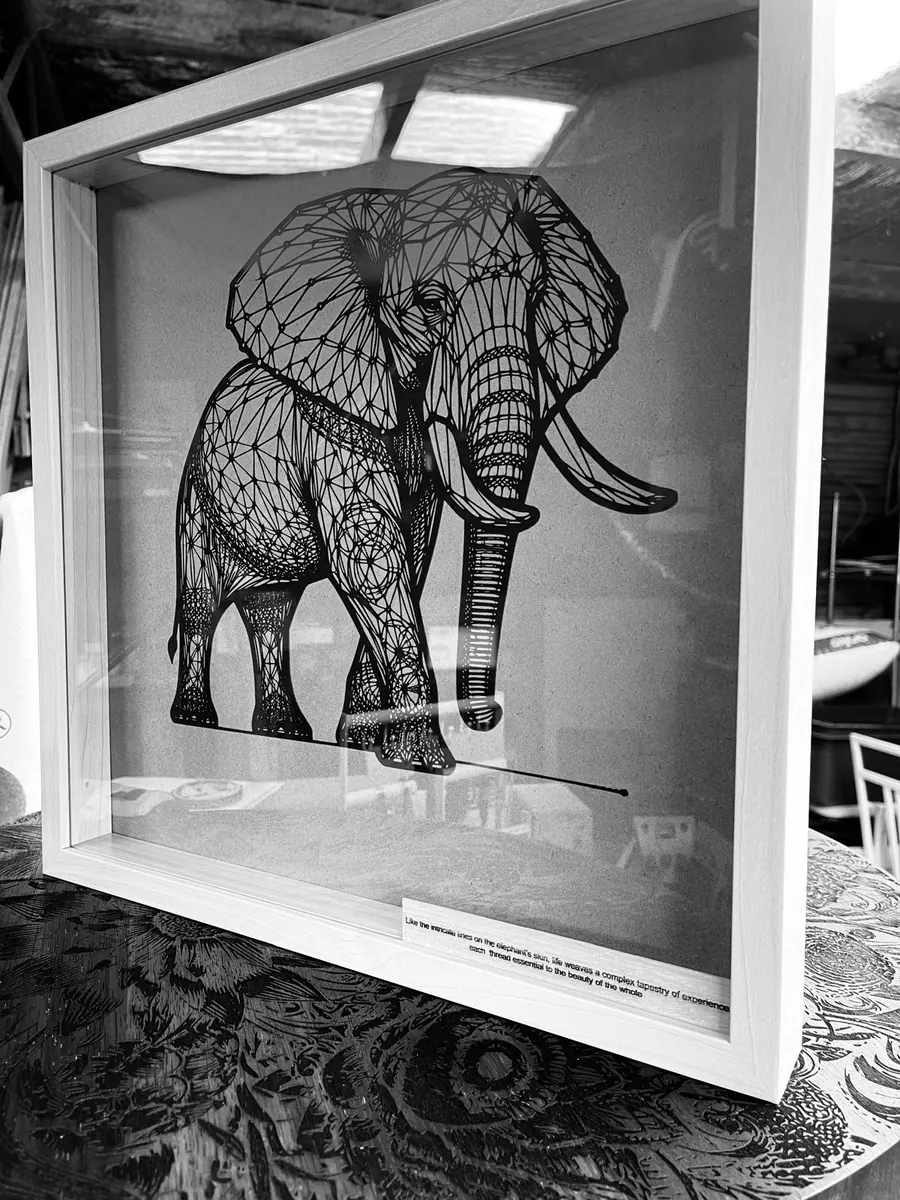 Framed geometric laser cut elephant wall art in fine black linework float mounted in a white box frame