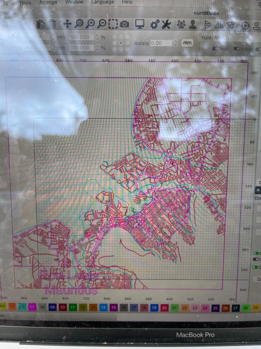 Laser cutting software on screen showing the layered vector design of a Port Louis, Mauritius map before cutting