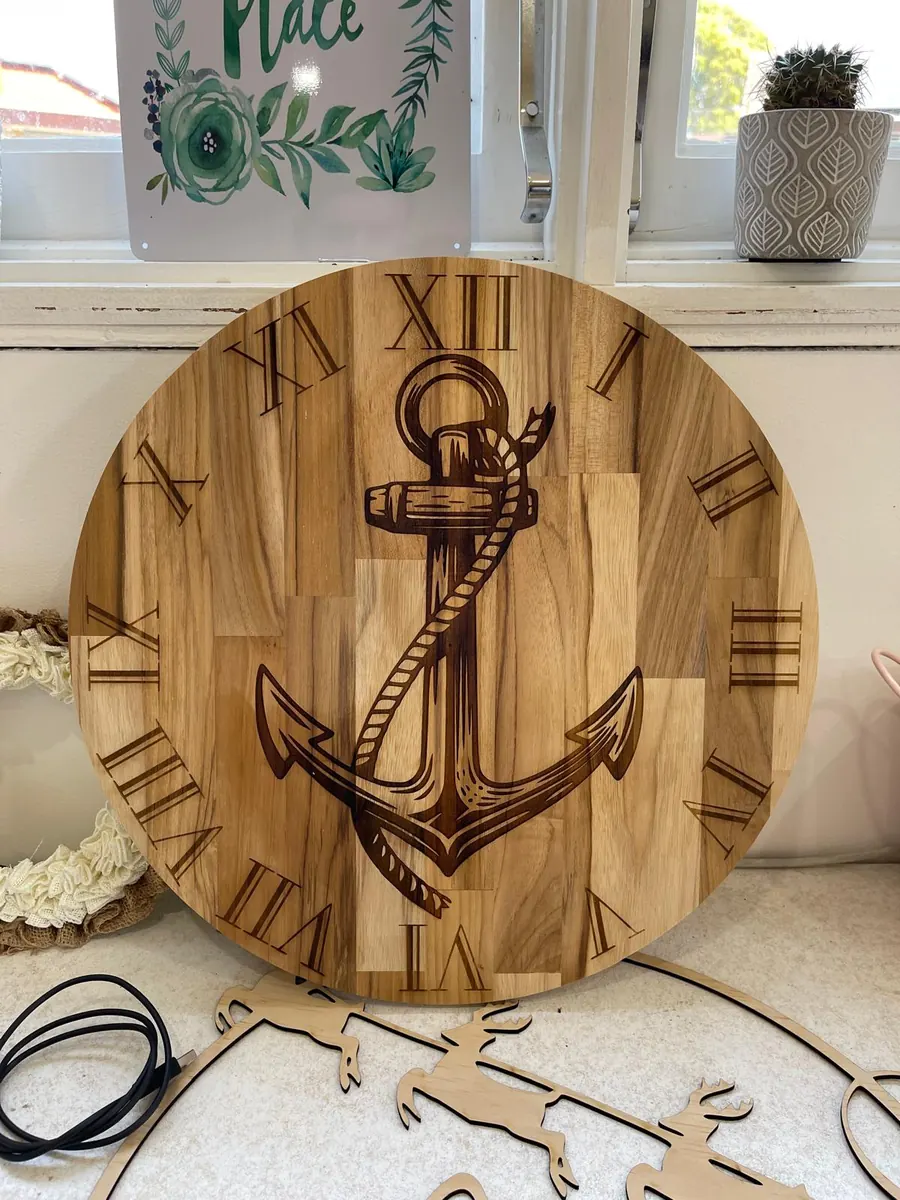 Round timber wall clock with a deeply laser engraved anchor and Roman numerals